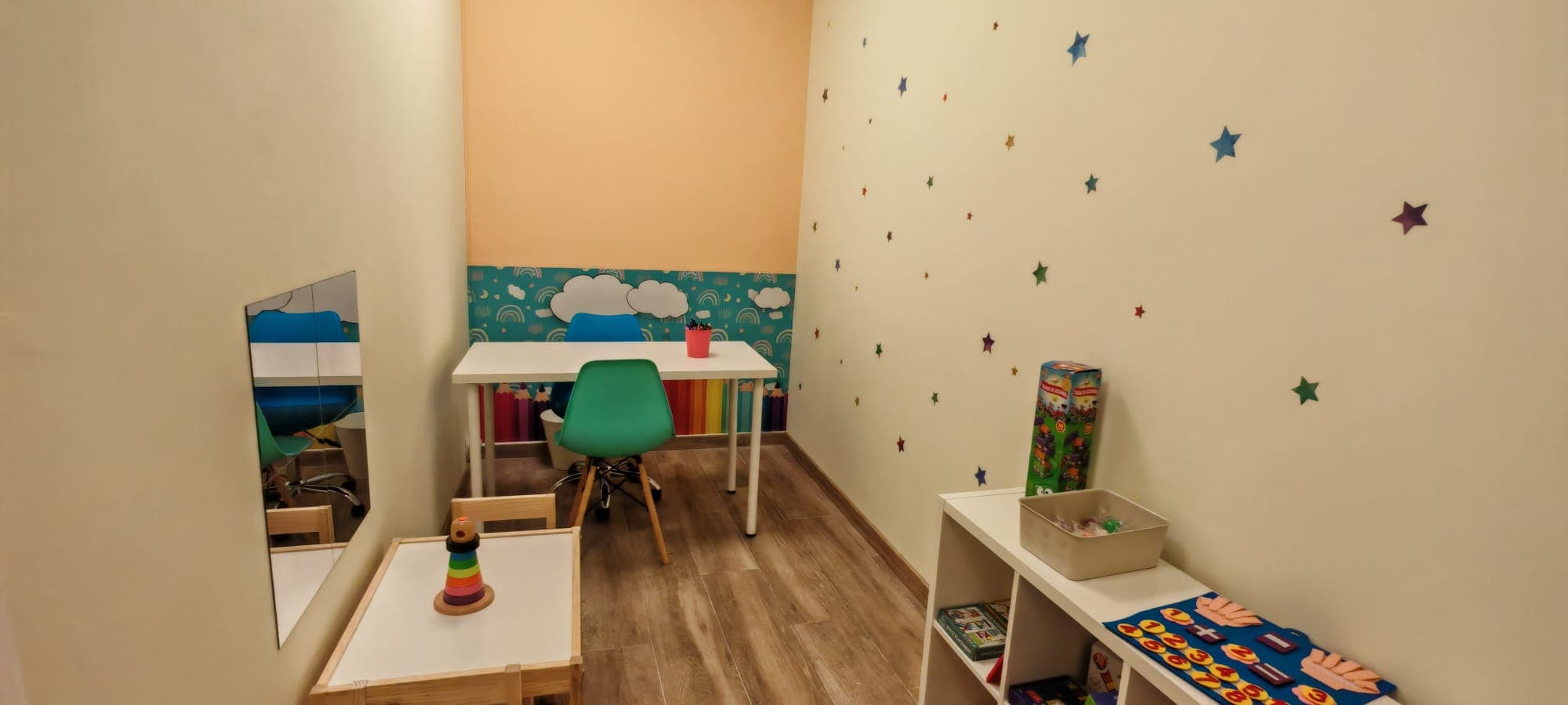 Sala de terapia con escritorio y decoración infantil